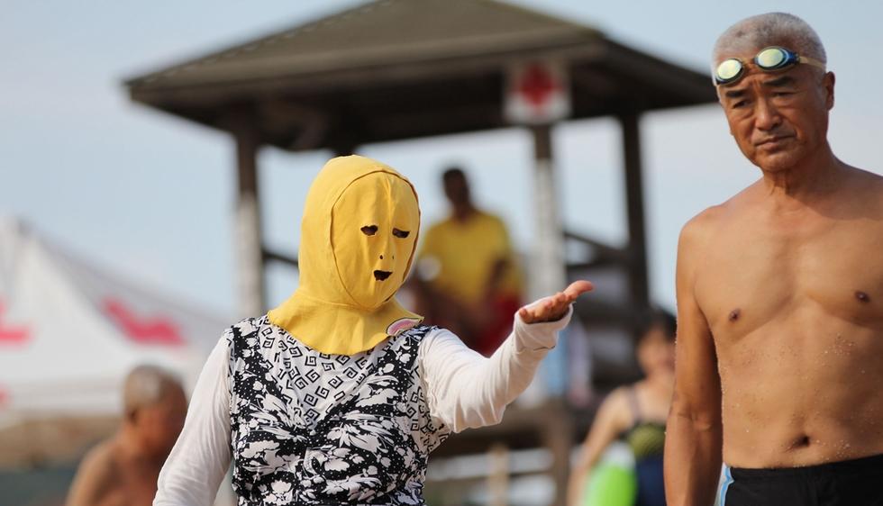 脸基尼大妈现青岛浴场 争艳比基尼美女(2)_uc图集 _光明网