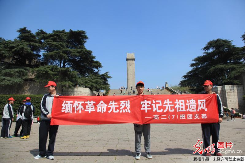 牢记先祖遗风"横幅并向游客发放介绍雨花台烈士陵园的资料