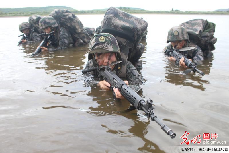 2017年7月13日,北部战区边防某旅官兵正在进行武装泅渡训练.