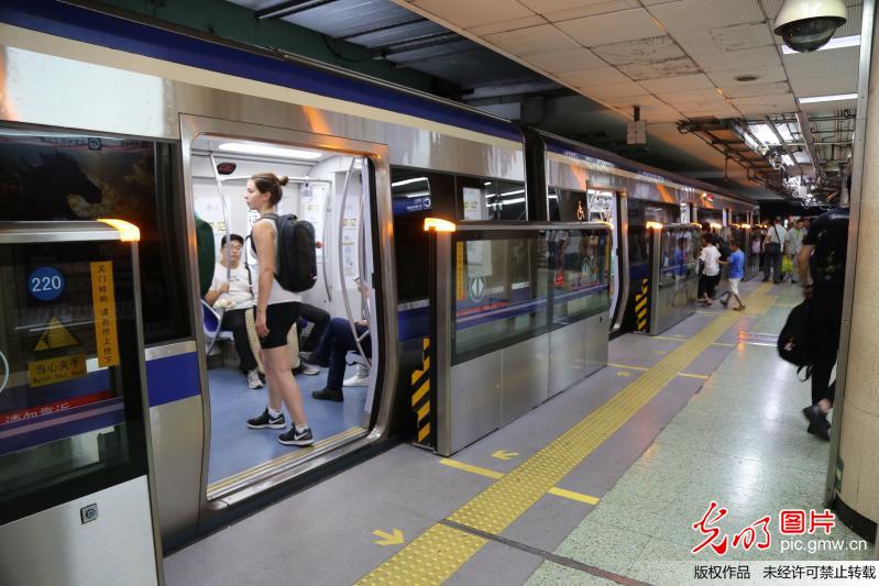 2017年8月20日,北京地铁2号线前门站台门启用,乘客在乘坐地铁.