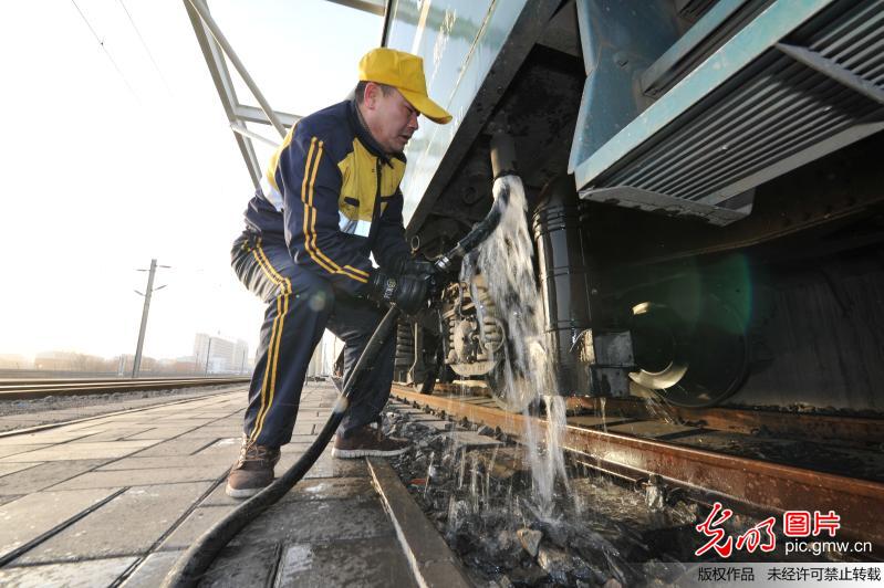 2018年1月15日,内蒙古包头铁路工作人员给停靠在包头火车站列车上水