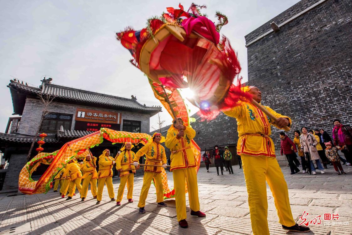 民间艺人在山东省潍坊市青州古城景区表演舞龙灯,喜迎新春到来