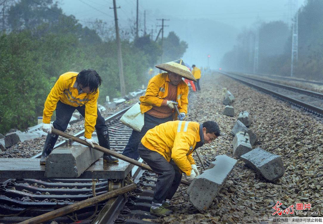 工人雨中抢修受损铁路