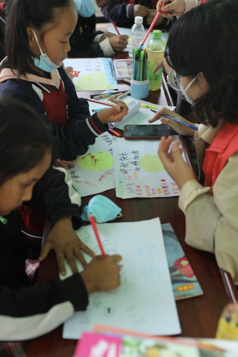 9月9日，在四川省石棉县王岗坪乡安置点内，志愿者在教小朋友画画。新华社记者 刘琼 摄