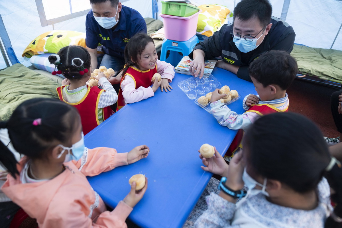 9月9日，在四川省石棉县新民乡海耳村临时安置点，四川省应急管理厅工作人员为孩子们送来中秋月饼。新华社记者 才扬 摄