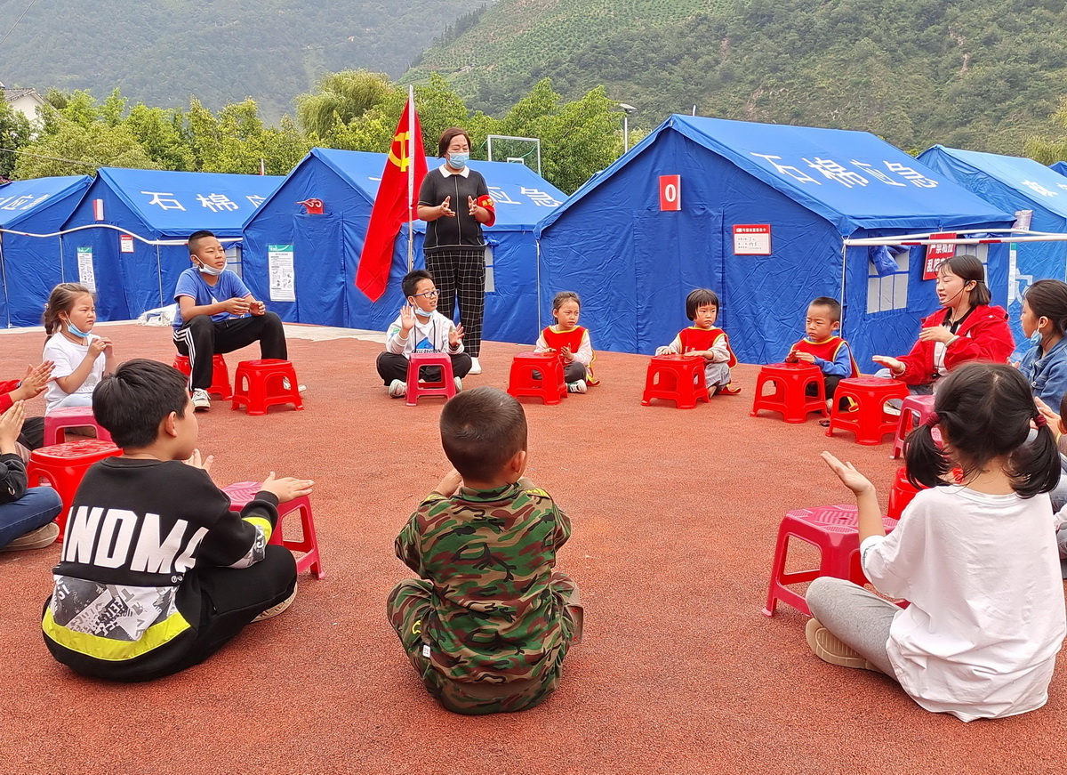 9月8日，在四川省石棉县新民乡海耳村临时安置点，老师带领孩子们做游戏。新华社发